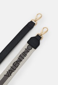 Correia de tecido preto com superfície texturizada e hardware em tom dourado, combinada com uma correia cinza apresentando "VALENTINO" impresso em letras maiúsculas pretas.