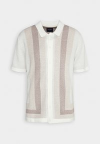 Korte mouwen gebreid shirt in crème met bruine horizontale strepen. Bevat een puntige kraag en knoopsluiting. Zachte textuur, casual ontwerp.