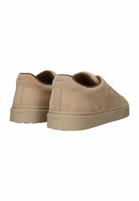 Zapatos de ante beige con punta redonda, suela de goma beige y logo estampado "BLACKSTONE" en el talón. Diseño simple y de bajo perfil.