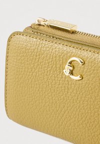 Μικρό υφασματοποιημένο πορτοφόλι ελιάς με χρυσό φερμουάρ και αλληλένδετο χρυσό λογότυπο CC στην μπροστινή πλευρά.