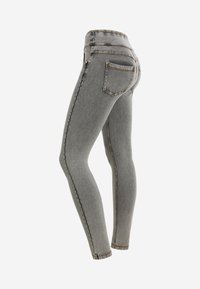 Jean skinny en denim gris avec une taille haute, des poches avant et arrière, des coutures contrastées et une texture lisse.