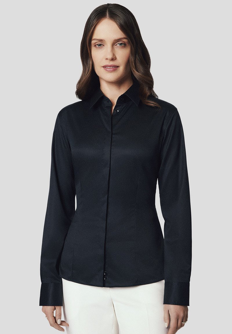 Czarna, długa koszula z guzikami o gładkiej fakturze, z charakterystycznym kołnierzykiem, dopasowanym krojem oraz guzikami na przodzie i mankietach.