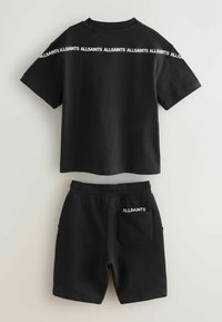 Schwarzes T-Shirt- und Shorts-Set. Das T-Shirt hat einen Rundhalsausschnitt und kurze Ärmel mit weißem "ALLSAINTS"-Logo auf der Rückseite. Shorts mit seitlichen Taschen.