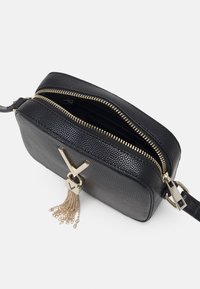 Borsa in pelle nera texture con hardware dorato, dotata di doppia cerniera, accentuazione a forma di V e dettaglio decorativo con frange.