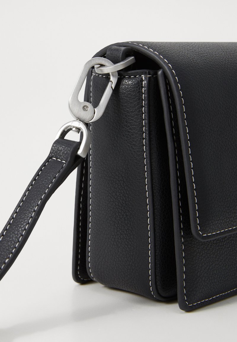 Borsa nera in pelle con finitura testurizzata, cuciture bianche a contrasto e chiusura in metallo silver su una tracolla. Forma compatta e rettangolare.