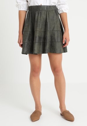 Groene faux leren rok met een uitlopende stijl, voorzien van horizontale naden en een elastische tailleband. De textuur lijkt glad met een lichte glans.