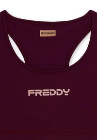 Top sportivo bordeaux con una texture liscia. Presenta uno scollo a taglio sulla schiena e un logo "FREDDY" rosa chiaro sul davanti.