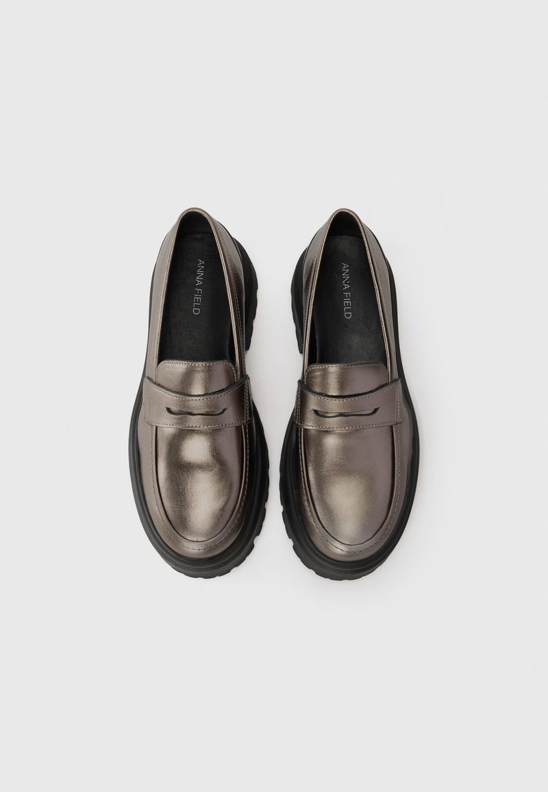 Metaliczne brązowe loafersy z gładkiej skóry, z detalem w postaci paska z przodu oraz grubą czarną gumową podeszwą.