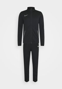 Zwarte Nike trainingsoutfit met een ritsjack en bijpassende tapered broek. Gemaakt van een glad materiaal met witte accenten en logo.