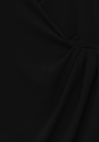 Tissu noir présentant des détails de drapés, une texture lisse et un léger éclat. Remarquable pour ses plis doux et sa silhouette fluide et délicate.