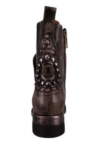 Metallisch brauner Knöchelstiefel mit einem gemusterten Absatz, der runde Nieten und einen Reißverschluss aufweist. Glatte Lederoberfläche mit einer abgerundeten Zehenpartie.