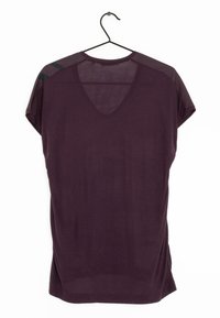 Burgunderfärgad kortärmad topp med V-ringning och transparent detalj på axlarna. Mjuk textur; fållen slutar vid midjan. Hänger på en svart krok.