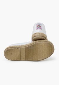 Espadrilles en toile blanche avec une semelle en caoutchouc texturé, présentant une broderie colorée de singe à l'avant et des accents en jute tressé au niveau du talon.