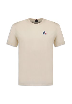 Cremfarbendes Baumwoll-T-Shirt mit kurzen Ärmeln. Es hat ein kleines blaues und rotes gesticktes Logo auf der linken Brust und einen runden Halsausschnitt.