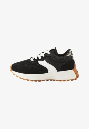 Czarno-biały sneaker wykonany z siateczki i materiału zamszowego, z amortyzowaną podeszwą i wzorzystym akcentem na pięcie. Gumowa podeszwa zewnętrzna zapewnia przyczepność.