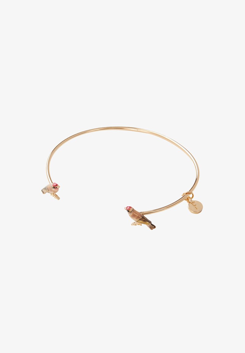Guldtonad bangle-armband med två detaljerade fågelberlocker med rosa accenter och en liten cirkulär tag fäst. Slät, rundad design.