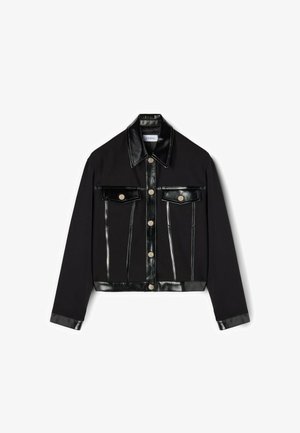 Jachetă scurtă neagră, cu un amestec de țesătură și piele ecologică. Butoane glisante argintii, două buzunare pe piept și detalii cu cusături în contrast.