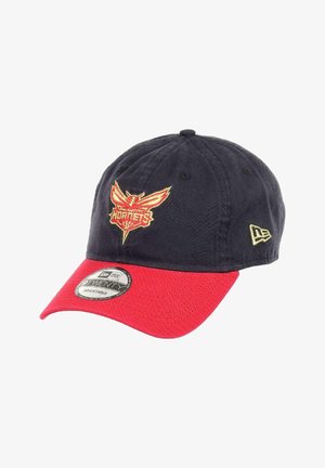 Baseball cap with a navy fabric body and red brim. Features an embroidered yellow and red "Hornets" logo on the front. Adjustable strap.