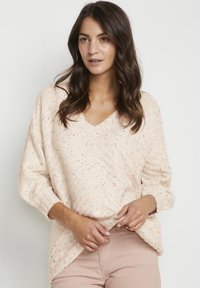 Maglione a V in maglia di colore rosa chiaro con macchie multicolori, caratterizzato da maniche corte e morbide e una vestibilità rilassata.