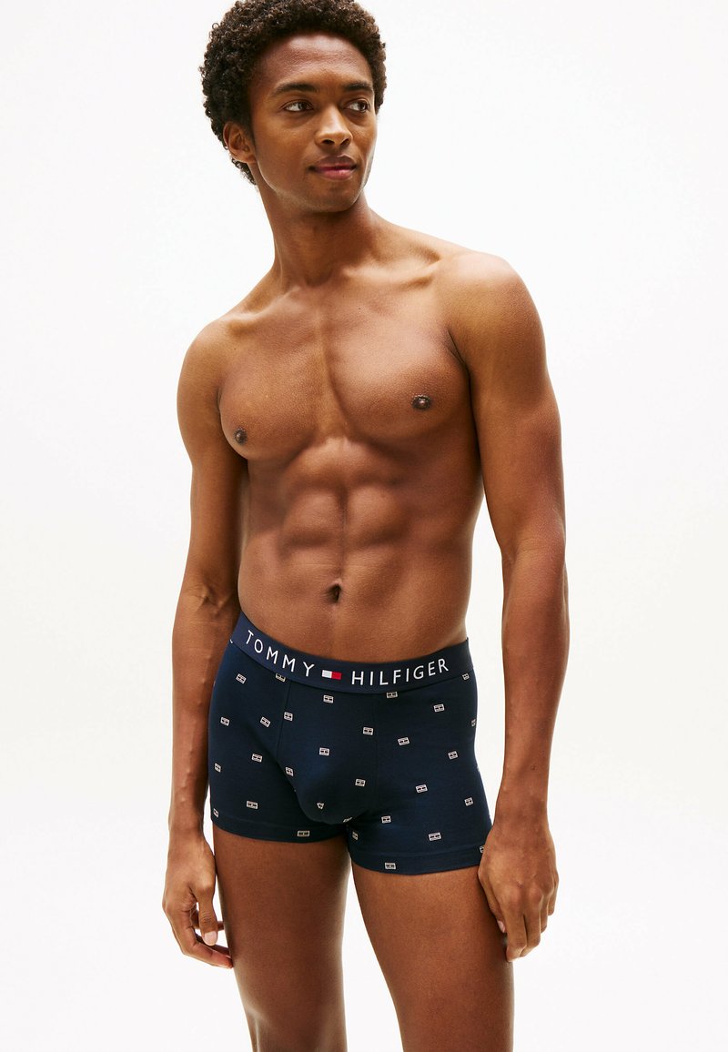 Boxer briefs de color marino con una cinturilla elástica de marca y pequeños patrones de logotipo en blanco. Tela suave con un diseño ajustado.