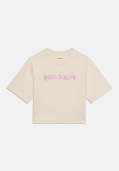 Beżowy krótki t-shirt z krótkim rękawem, z różowym stylizowanym napisem "Palm Angels" umieszczonym na środku klatki piersiowej.