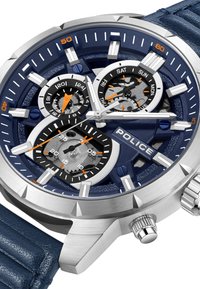 Vyriškas laikrodis su nerūdijančio plieno korpusu, tamsiai mėlynu ciferblatu, oranžiniais akcentais ir tekstūruota tamsiai mėlyna odine apyranke. Yra keli subciferblatai.