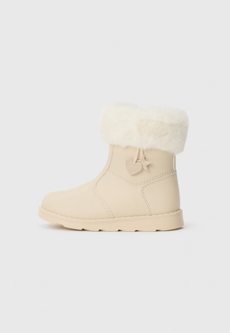 Bež antilop čizme do gležnja s umjetnim krznom, glatke teksture, okruglog vrha i meke potplate koja ima akcent u obliku srca sa strane.