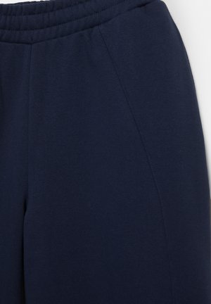 Pantaloni sport bleumarin cu talie elastică și buzunare pe cusăturile laterale, confecționați dintr-un material moale și confortabil.