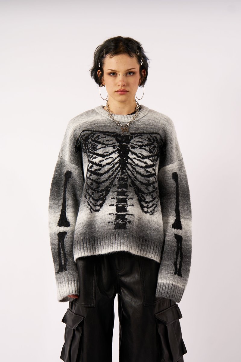 Grå og sort strikket sweater med et skelet ribben design. Brede ærmer og ribbet kant. Sammen med højwaistede sorte cargo bukser.