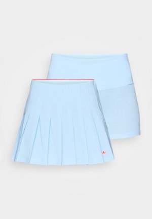 Due gonne azzurro chiaro, una plissettata con un logo rosso vicino all'orlo e una liscia con pannello in rete, esposte su uno sfondo bianco.