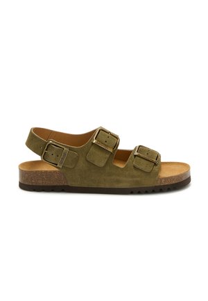 Sandale en daim vert olive avec trois boucles en laiton réglables, semelle en liège et semelle extérieure en caoutchouc noir, vue de profil.