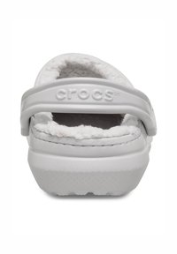 Witte Crocs met een zachte binnenvoering, voorzien van een achterband, glad plastic materiaal en een geribbeld profiel voor grip.