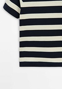Top en maille à manches courtes avec larges rayures horizontales bleu marine et blanches, vu de côté sur fond blanc.