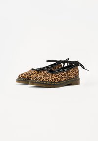 Scarpe con stampa leopardata, lacci neri, sole in gomma, punta rotonda e dettagli in cuciture gialle. Presentano una texture simile al camoscio e un design a profilo basso.
