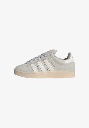 Grey suede sneakers with white leather accents, three white stripes, and light-colored rubber sole. Features flat laces and round toe design.