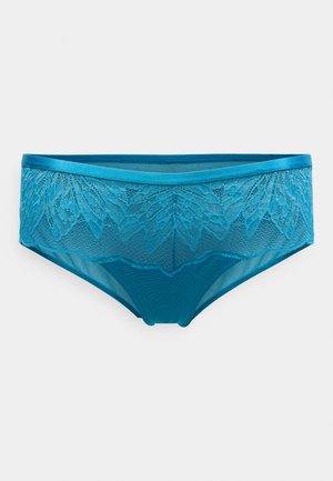 Slip in pizzo turchese con bordo smerlato e sovrapposizione in pizzo strutturato, caratterizzato da una cintura liscia e una parte posteriore semi-trasparente.