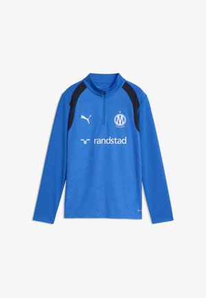 Niebieska sportowa koszulka z długim rękawem i czarnymi panelami na ramionach, logo Puma, godłem Olympique de Marseille oraz logo sponsora Randstad na przodzie.