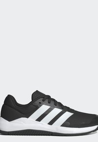 Chaussure de course Adidas noire et blanche avec trois bandes blanches sur le côté, lacets noirs et semelle blanche texturée.