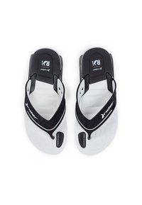 Schwarz-weiße Sandalen mit einem strukturierten schwarzen Riemen, einer weichen Fußbett und einer durchsichtigen Sohle mit Logo-Detail auf dem Fußbett.