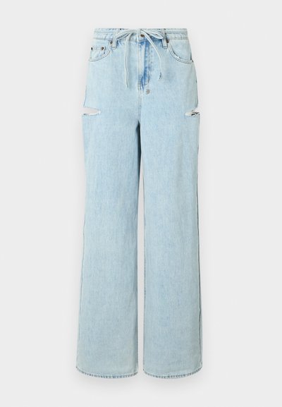 Lyseblå denim vide bukser med snøring i taljen, med to hull i knærne og en ren kant. Myk tekstur med en avslappet passform.
