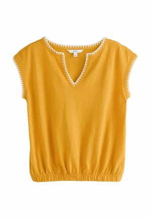 Mustard yellow short-sleeve top with V-neck and white zigzag trim, elasticated hem, and decorative stitching on sleeves and neckline.