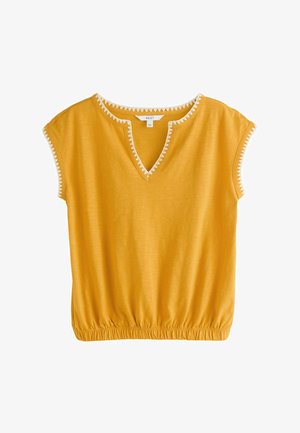 Mustard yellow short-sleeve top with V-neck and white zigzag trim, elasticated hem, and decorative stitching on sleeves and neckline.