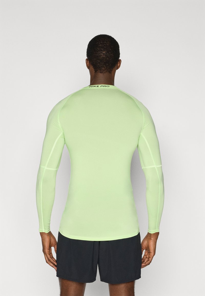 Hellgrünes, langärmliges Sportshirt aus glattem, dehnbarem Stoff mit körpernahem Schnitt und "NIKE PRO"-Logo am Kragen.