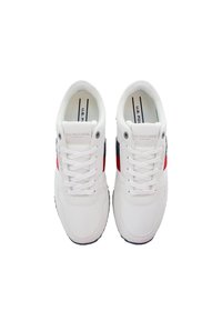 Bílé tenisky vyrobené z mřížkového a syntetického materiálu, s červenými a námořnickými pruhy, kulatou špičkou a tradičním šněrováním. Text na jazyku a boku.