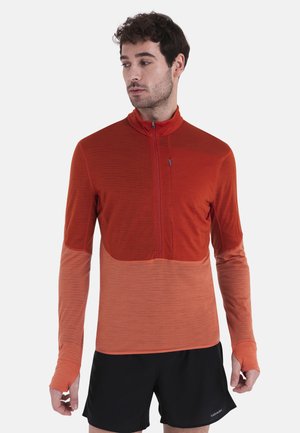Langärmliges Quarter-Zip-Oberteil mit einem Farbverlauf in Rottönen und Orange, aus strukturiertem Material mit einem weichen Finish.
