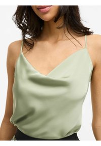 Satin-Camisole in Hellgrün mit V-Ausschnitt, dünnen verstellbaren Trägern und einer weichen, glatten Textur.