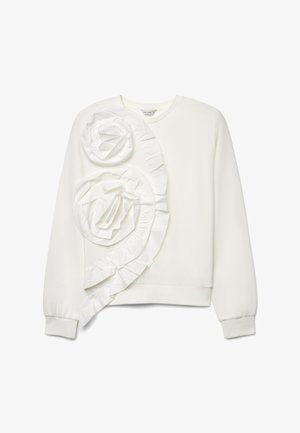 Sweat-shirt blanc à manches longues avec deux grandes rosaces en tissu et un volant décoratif sur le côté gauche devant.