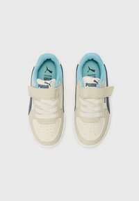 Beige színű szintetikus bőr felsőrésszel, fehér fűzőkkel, kék belső párnázással és tépőzárral ellátott sneaker. A side accents had navy színűek.