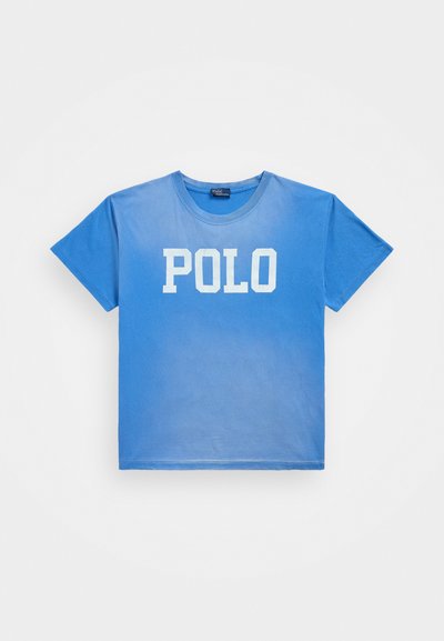 Modra bombažna majica s gradientnim dizajnom in izrazitim belim napisom "POLO" spredaj. Klasičen okrogli izrez in kratki rokavi.