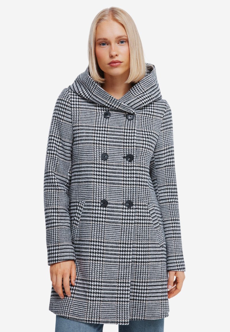 Double-breasted hoodie in zwart-wit houndstooth patroon, voorzien van twee grote zwarte knopen en zijzakken. Geverfd stof.